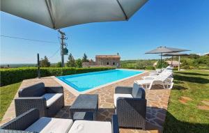 a swimming pool with chairs and an umbrella at Villa Ciano in Višnjan +42 photos