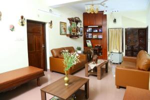 un soggiorno con divani e un tavolo di Jasmin Villa a Cochin