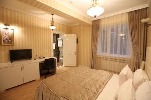 a bedroom with a bed and a desk and a television at Old Street Boutique Hotel in Baku