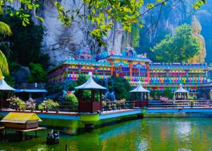 a building in the middle of a lake in front of a mountain at ARK Wave Hotel Ampang in Ampang