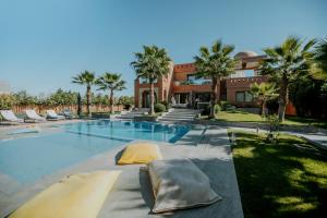 a swimming pool with two pillows in front of a building at DAR KAYIS & LAILA in Marrakesh