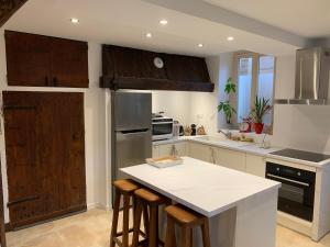 a kitchen with a white counter top and wooden cabinets at L Entre deux choses in Saint-Pierre-de-Bailleul