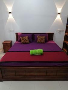 Un dormitorio con una cama grande con sábanas y almohadas moradas. en Jungle House, en Unawatuna