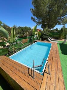a pool on a wooden deck with a chair next to it at Nómada, Casa Cerca de Sevilla in Alcalá de Guadaira