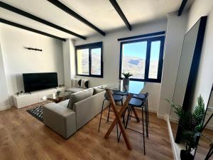 a living room with a couch and a table at Triplex Loft Mountain ZONA BAJA in Sierra Nevada