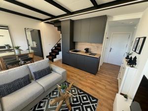 a living room with a couch and a kitchen at Triplex Loft Mountain ZONA BAJA in Sierra Nevada