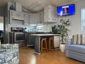a kitchen with white cabinets and a tv on the wall at Seaside Therapy in Myrtle Beach