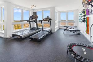 un gimnasio con dos máquinas de correr y ventanas en ML186 First Floor WiFi EZ Gated Parking Near Village Slopes, en Snowshoe 5 fotos más