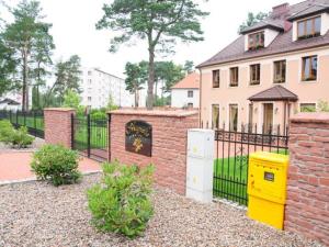 a house with a brick fence and a yellow box at SAS Militaria dla 2 par 2 pokoje 4 osoby in Borne Sulinowo