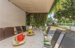 stół z miską arbuza i miską owoców w obiekcie Holiday Home Bibinjskih Mlikaric Bb Iv w Bibinje