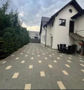 a patio with chairs and a white building at Holidays Home 4 You in Rădăuţi