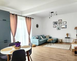 a living room with a blue couch and tables at ADM Cozy Home - Entire private house&garden, close to Therme and Airport in Tunari