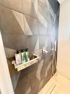a bathroom with a shower with a shelf with toiletries at Kallisti Suite in Mykonos Town in Mýkonos City