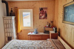 a bedroom with a bed and a television and a window at Cà Rostida in Vermiglio