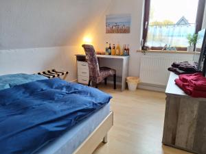 a bedroom with a bed and a desk and a chair at Pension Entenhausen in Schwentinental