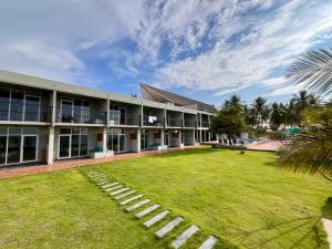 a large building with a lawn in front of it at Hiru Beach Resort in Kalpitiya