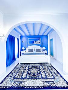 a blue bedroom with a white bed and blue walls at Jungwok Blue Ocean Resort in Ngandong