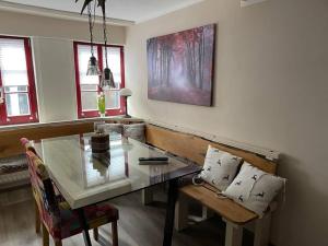 a dining room with a glass table and a bench at Ferienhaus Charlotte in Goslar