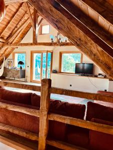 a living room with couches and a flat screen tv at Ferme rénovée Serre Chevalier in Saint-Chaffrey