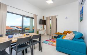 salon ze stołem i niebieską kanapą w obiekcie Pet Friendly Apartment In Malinska w mieście Malinska