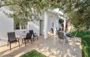 a patio with a table and chairs under a tree at Apartment Mimice Mimice Brig Iii in Mimice