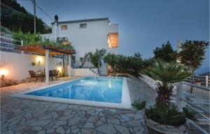 a villa with a swimming pool in front of a house at Apartment Mimice Mimice Brig Iii in Mimice