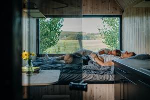 a man and a woman laying on a bed at AIVA Glamping in Partizánske