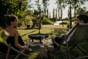 two women sitting in lawn chairs in a yard at AIVA Glamping in Partizánske