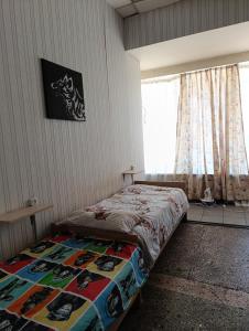a bedroom with a bed with a quilt on it at Хостел Sweet Home in Mykolaiv
