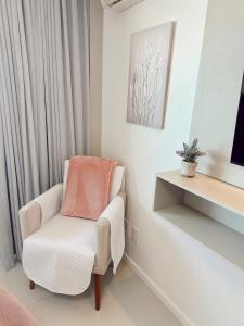 a white chair in a room with a desk at Praia da Costa, SUNRISE STAY in Vila Velha +22 photos