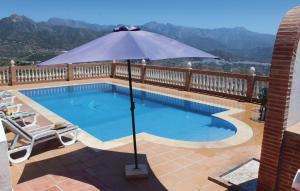 basen z parasolem na patio w obiekcie Gorgeous Home In Torrox With Kitchen w mieście Torrox