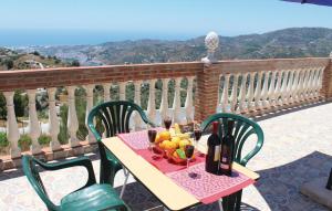 stół z miską owoców i butelkami wina w obiekcie Gorgeous Home In Torrox With Kitchen w mieście Torrox