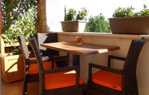 a table and chairs sitting on a patio with plants at Beautiful Apartment In Rakalj With Wifi in Rakalj