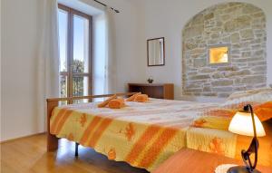 a bedroom with a bed with a stone wall at Beautiful Apartment In Rakalj With Wifi in Rakalj