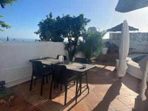 Una mesa y sillas en un patio con vista al mar. en Studio Apartment Maro Casa Vistamar, en Maro