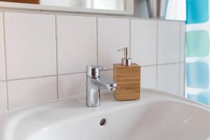 - un lavabo dans la salle de bains avec un porte-brosse à dents. dans l'établissement Pretty Home Skyline Work & Stay, à Chemnitz 14 autres photos