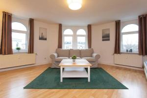 un salon avec un canapé et une table dans l'établissement Pretty Home Skyline Work & Stay, à Chemnitz