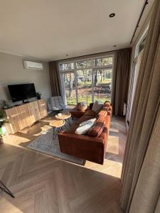 een woonkamer met een bank en een tafel bij Bos chalet Hellendoorn met Hottub in Haarle