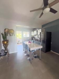 a kitchen with a table and chairs and a refrigerator at La Marquise in Flic-en-Flac