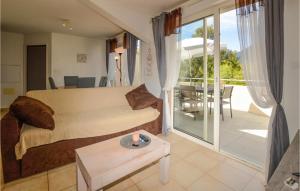 ein Wohnzimmer mit einem Bett und einem Tisch sowie einem Balkon in der Unterkunft Lovely Apartment In Sta Maria Poggio in Santa-Maria-Poggio