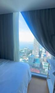 a bedroom with a window with a view of a city at JohnStay in Manila +13 photos