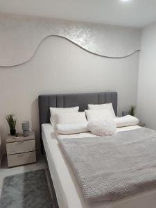 una camera da letto con un letto grande con cuscini bianchi di RAS ROYAL TRESKA ESCAPE Kopaonik a Kopaonik