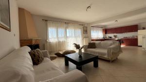 a living room with a white couch and a table at All Seasons Apartments in Alexandroupoli