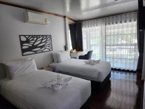 Postel nebo postele na pokoji v ubytování BanFarang - บ้านฝรั่ง