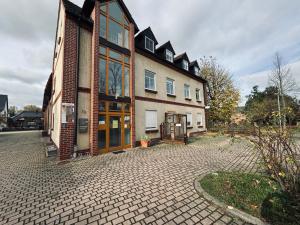 a large house with a brick driveway in front of it at Ferienwohnung Krippehna in Zschepplin