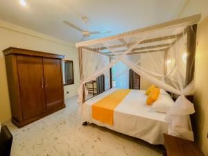una camera da letto con letto a baldacchino e finestra di Solace Inn RESIDENCE - 5 Min Walk to Beach a Tangalle