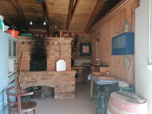 a brick fireplace in a kitchen with a table and a stove at Berkenyés Vendégház in Zalalövő