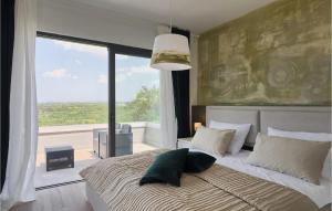 a bedroom with a large bed with a large window at Villa Primavera in Buje