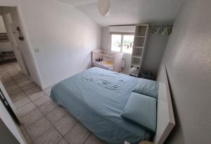 een kleine slaapkamer met een bed en een wieg bij Maison in Sainte-Marie-la-Mer