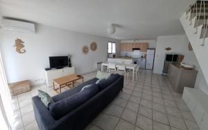 een woonkamer met een blauwe bank en een keuken bij Maison in Sainte-Marie-la-Mer +2 foto's